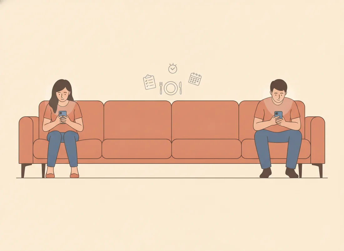 Two partners sitting at opposite ends of a long sofa, each on a phone